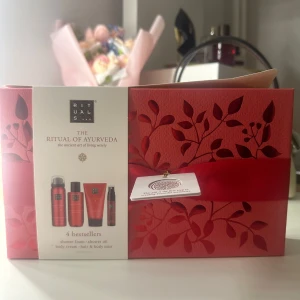 Rituals The Ritual of Ayurveda presentbox - Lyxig presentbox från Rituals med serien The Ritual of Ayurveda. Innehåller fyra bästsäljare: shower foam, shower oil, body cream och hair & body mist. Produkterna kommer i snygga röda flaskor och tuber, förpackade i en elegant röd ask med blommönster och sidenband.