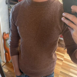  stickad tröja  - Ge gärna prisförslag!!! Mysig brun/röd stickad tröja från these glory days med rund halsringning och ribbade muddar. Tröjan har en enkel och stilren design, perfekt för lager-på-lager. Långärmad och i ett mjukt material som håller dig varm under kyliga dagar. Tröjan är i s, men passar mer som XS.