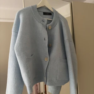 Ljusblå kofta från Primark - Supermysig ljusblå kofta från Primark med stora knappar framtill och två fickor. Koftan är stickad och har en loose passform med långa ärmar och ribbade detaljer vid krage, ärmslut och nederkant. Perfekt för lager-på-lager under kyliga dagar.