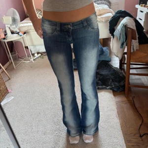 Blå bootcut jeans - Snygga blå bootcut jeans med låg midja och slitna detaljer från cheap Monday. Aldrig använda