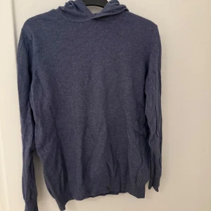 Oscar Jacobson hoodie, blå - Mysig blå hoodie från Oscar Jacobson i storlek M. Tröjan är tillverkad i Italien och har en klassisk huva samt långa ärmar. Perfekt för dig som gillar stilren och enkel design med en soft känsla.