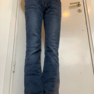 Blå bootcut jeans från SHEIN - Snygga blå bootcut jeans från SHEIN i klassisk femficksmodell. Är tillverkade av 85% bomull, 13% polyester och 2% elastan för en skön stretchig känsla. Passar dig som gillar retrovibbar och vill ha ett par jeans med lite utsvängda ben.