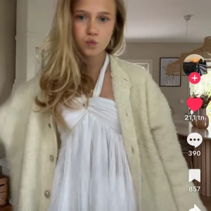 Vit efterfrågad topp - Supersöt vit topp med halterneck och knyt i nacken. Toppen är plisserad och tight upptill, flowy nedåt och snygga detaljer som twistad front. Perfekt för sommaren och fest. Kan skicka fler bilder. Obs, toppen är lite tight upptill och därför säljer jag den här då jag inte har kvittot. Den har prislapp på, kan tvätta den innan jag postar. Väldigt efterfrågad och trendig, liknar en gammal rosa från Zara.