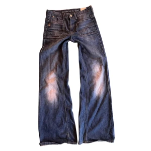 Blå bootcut jeans med slitningar från G-star - .Säljer ett par snygg g-star jeans i storlek 27/34, de passar mig bra som är 163 Innerbenslängd: 79cm Midjemått: 74cm