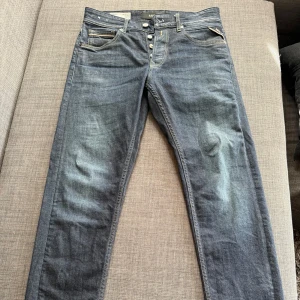 Replay Grover jeans straight fit blå - Snygga Replay Grover jeans i klassisk blå tvätt med raka ben och kontrastsömmar. Jeansen har fem fickor, knappgylf och stilrena slitningar framtill. Perfekta för dig som gillar en avslappnad look på dina jeans 🔥