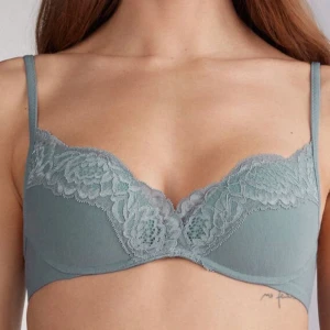 snygg spets-bh från Intimissimi - Säljer en bh från Intimissimi! Den är gråblå med blommig spets upptill. Den har tunna axelband och snygg form. Perfekt för dig som gillar fina detaljer och vill ha något extra under kläderna🩷. De är oanvända ❤️