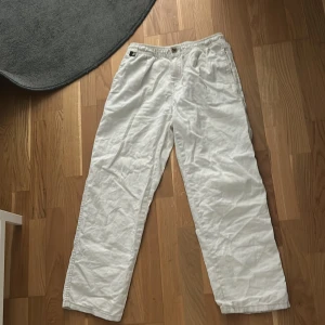 Vita linnebyxor från Zara, stl 164 - Snygga och luftiga vita linnebyxor från Zara med elastisk midja och rak passform. Byxorna har en bakficka med knapp och är perfekta för varma dagar. Stilen är avslappnad och passar dig som gillar en clean och enkel look. Pris kan diskuteras 