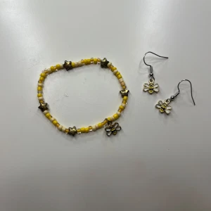 Super sött armand och örhängen  - Supergulliga handgjorda örhängen med små bin samt ett gult armband med stjärnor och ett hängande bi. Örhängerna är en hängande modell med krokar som är lätta att sätta i. Säljs som ett kit med armand och örhängen för 50 kr eller örhängerna för 30 och armbandet för 40. 