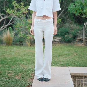 Vita bootcut jeans från H&M - Snygga vita bootcut jeans från H&M i storlek 36. De har låg midja och klassisk femficksdesign. Jeansen är tillverkade i denim och har en stilren look som passar perfekt till sneakers eller boots.