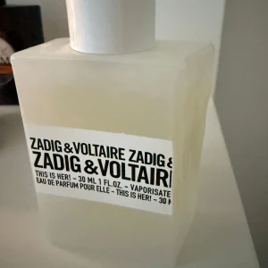 Zadig & Voltaire This Is Her! 30ml EdP - Parfymflaska i matt vit glas med minimalistisk design och svartvit etikett. Märkt med 'This Is Her!' och rymmer 30 ml Eau de Parfum. Flaskans lock är vitt med Z&V-logga i relief. Inte alls använd!💞