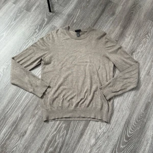 Beige slim fit tröja från H&M - Snygg beige långärmad tröja från H&M i slim fit-modell. Tröjan har rund halsringning och är tillverkad i ett mjukt material som känns skönt mot huden. Perfekt för lager-på-lager och enkel att matcha med olika outfits.