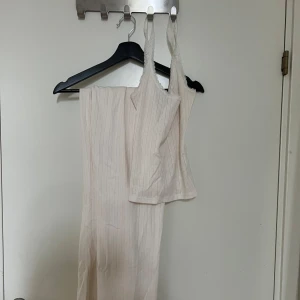 Ljusrosa mjukis set med linne och byxa - Mjukisset med super söt topp som har en spetsdetalj, och långa byxor med volangkant nedtill