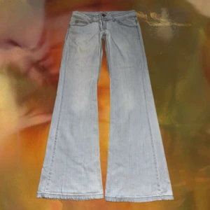 Ljusblå bootcut jeans från TrDenimRules - Säljer ett par ljusblå jeans från TrDenimRules med klassisk femficksdesign och bootcut-ben. Jeansen är lågmidjade och är tillverkade i mjukt denimtyg. Perfekt för dig som gillar retrovibbar och vill ha ett par jeans med riktigt snygg siluett. 42 höft , innerbenslängd 89