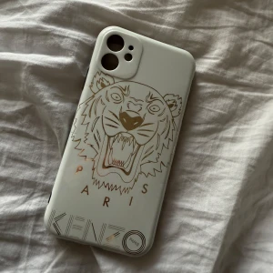 Kenzo skal - Säljer ett mobilskal med ett tigertryck och texten 'KENZO PARIS'.