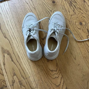 Vita sneakers från Vagabond i mocka - Snygga vita sneakers från Vagabond med chunky platt sula och rund tå. Skorna är gjorda i mjuk mocka och har snörning framtill. Perfekt för dig som gillar stilrena och cleana vibes. Storlek 37.