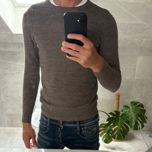 Brun merinoulltröja  - Merinoull tröja från A days march. Storlek är S. Fick i present så vet inte nypris. Jag på bilden är 184 väger 70