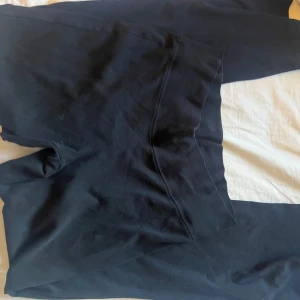 Svarta yoga pants från H&M - Svarta mjukisbyxor från H&M i storlek M. Byxorna har en enkel och avslappnad look med raka ben och resår i midjan. Perfekta för chill dagar eller när du vill vara bekväm. Tillverkade i mjukt bomullsmaterial.