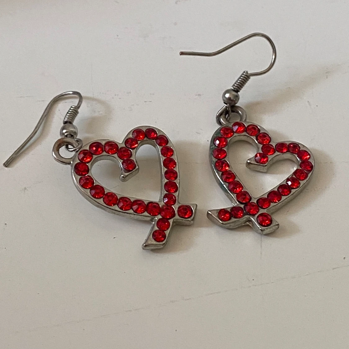 Silvriga örhängen med röda hjärtan
