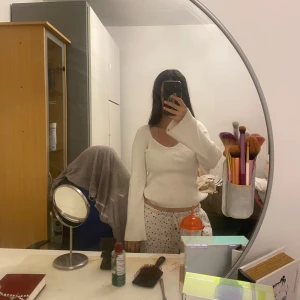 Vit ribbad tröja från vero Moda  - Säljer en vit ribbad tröja från AWARE med snygg, djup rundad ringning och långa ärmar. Tröjan är figurnära och har en mjuk, stretchig känsla. Perfekt att styla med jeans eller kjol för en clean look. Köpt för 400 kr.