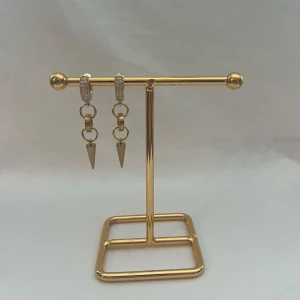 Guldiga örhängen med strass och spikes - Säljer ett par snygga örhängen i guldton med glittriga strass på ringen och coola hängande spikes. Designen har kedjelänkar som ger en edgy vibe och passar perfekt om du vill sticka ut. Perfekt accessoar för att lyfta din stil.