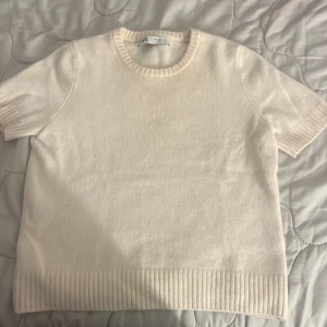 Vit stickad kortärmad tröja från Zara -  vit stickad tröja med korta ärmar och ribbade detaljer vid hals.