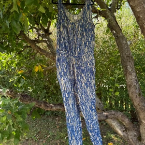 Blåvit mönstrad jumpsuit Vero Moda XL - Snygg ärmlös jumpsuit från Vero Moda i storlek XL. Mönstret är blått och vitt med abstrakta penseldrag, och modellen har v-ringad hals och markerad midja. Perfekt för dig som gillar bekväma och trendiga plagg med unik look. Helt ny med tags/ prislapp fortfarande kvar. 