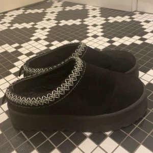 Svarta mockatofflor med platåsula - Uggs liknande tofflor. Små skavanker på framsidan av skon!