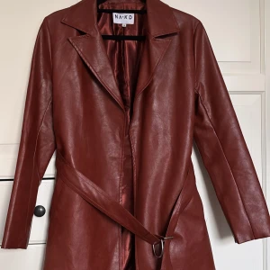 Brun skinn trenchcoat  NA-KD - Snygg brun trenchcoat i läder/PU från NA-KD. 