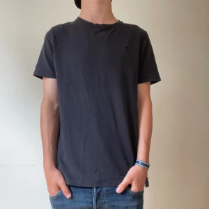 Svart t-shirt från Morris - En stilren svart t-shirt från Morris med diskret broderad logga på bröstet. Klassisk passform, rund hals och korta ärmar. Tillverkad i mjuk bomull som är skön mot huden. Perfekt för en clean och avslappnad look. Modellen är 174 och väger ca 60kg.