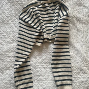 Randig stickad tröja från Cider - Superfin stickad tröja från Cider i vitt och svart med klassiskt randigt mönster. Tröjan har lång ärm, ribbade muddar och en rund halsringning. Perfekt för dig som gillar en chill och tidlös look.