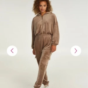 Beige velour jumpsuit från Hunkemöller - Mysig beige jumpsuit i mjuk velour från Hunkemöller. Modellen har huva, dragkedja framtill, resår i midjan och muddar vid ärm- och benslut. Snygga cargofickor på benen ger en chill vibe. Perfekt för slappa dagar eller när du vill vara extra comfy. Endast testad, legat i garderoben ett bra tag.