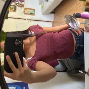 Vinröd  topp - Säljer en vinröd croppad topp med korta ärmar och ribbad struktur. Toppen har en rund halsringning och sitter tight mot kroppen. Perfekt att matcha med jeans eller kjol för en chill och snygg look. 🤩🤩