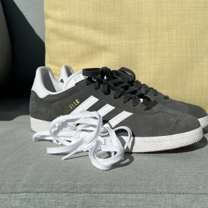 Adidas Gazelle  - Tja! Säljer nu dessa snygga adidas Gazelle gråa! De är perfekta till sommaren. De är helt oanvända men boxen finns tyvärr inte kvar när den kastades av misstag. Nypris är 1349. Vårt pris 1100. Kan gå lägre. Ett par vita skosnören medföljer också!  Hör av er vid funderingar och frågor så svarar vi på den så snabbt vi kan! 