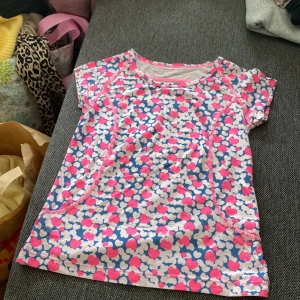 Färgglada leggings och tränings tröja från H&M Sport - Säljer ett par leggings från H&M Sport med ett lekfullt mönster i rosa, blått och vitt. De har elastisk midja och är gjorda i ett stretchigt syntetmaterial, perfekta för träning eller chill. Mönstret består av hjärtan och prickar som ger en riktigt poppig look.