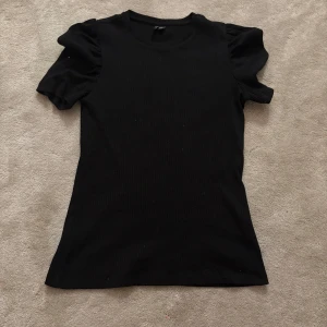 Svart ribbad topp med puffärm - En svart ribbad topp med korta puffärmar. 🤩