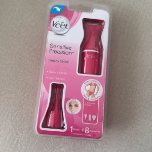 Veet Sensitive Precision Beauty Styler - Veet Sensitive Precision Beauty Styler i rosa plast, perfekt för att forma och trimma känsliga områden som ansikte, bikinilinje och armhålor. Inkluderar flera tillbehör för olika stylingmöjligheter och drivs med AA-batteri. Kompakt och smidig design.