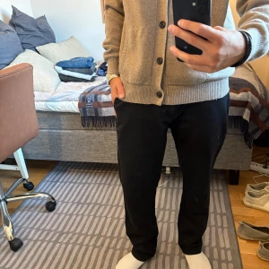 Svarta Chinos  - Snygga svarta chinos med rak passform och klassisk look. Passar M i längden. Perfekta till en stilren outfit och passar till många olika tillfällen. Från Number Homme. 