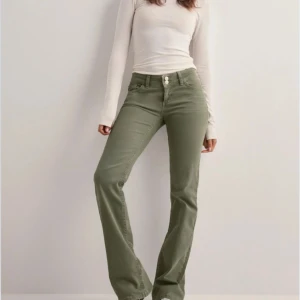 gröna Nelly jeans - Snygga olivgröna byxor med bootcut-snitt och normal passform. Byxorna har klassisk femficksdesign, knapp och dragkedja framtill. Perfekta för dig som vill ha en stilren och trendig look.