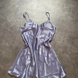 Ljuslila satin klänning Secrets - Supersöt ljuslila kortklänning i glansigt satinmaterial från Secrets Lingerie. Klänningen har tunna axelband och en flowy passform som ger en riktigt chic vibe. Perfekt för dig som gillar en enkel men ändå elegant look. Storlek M men passar även S. Går också att ha som nattlinne om man vill🫶🏼