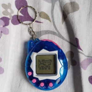 Tamagotchi - En blå tamagotchi med rosa knappar ^^ kan användas som en keychain