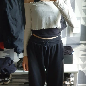 Vit croppad offshoulder tröja - Säljer en vit croppad offshoulder tröja med lång ärm. Tröjan har ribbad struktur och vågig kant nertill för en trendig look. Perfekt för dig som gillar en stilren men edgy vibe.