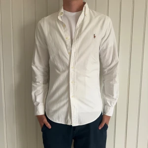 Ralph Lauren Skjorta - En nice vit Ralph Lauren skjorta slim fit, perfekt till sommarkvällar. Storlek S. Skick 9,5/10. Hör gärna av er vid frågor och funderingar. Pris går självklart att diskuteras!🤗