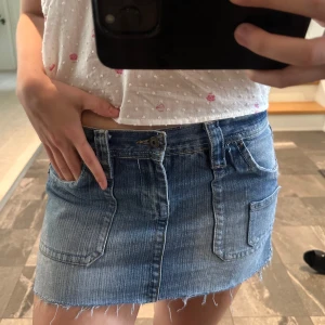 Blå jeanskjol  - Snygg blå jeanskjol med rå, fransig kant nertill och stora fickor både fram och bak. Broderad detalj på bakfickorna ger extra stilpoäng. Perfekt nu till sommaren!💛🌸😇pris kan diskuteras!!