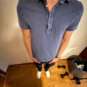 Blå pikétröja från Moncler - Säljer en stilren blå pikétröja från Moncler med klassisk krage och tre knappar framtill. Tröjan har korta ärmar och Moncler-logga på vänster ärm. Tillverkad i bomull för en skön och luftig känsla. Storlek XS. Pris går att diskuteras.
