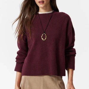 Vinröd stickad tröja från & Other Stories - Mysig vinröd kashmirtröja från & Other Stories med rund halsringning och breda ribbade muddar. Tröjan har en loose passform och långa ärmar, perfekt för lager på lager under höst och vinter. Enkel och stilren design som är lätt att matcha.