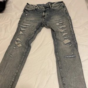 Skinny slitna jeans från H&M - Säljer ett helt nytt💯 par skinny jeans från H&M i ljusblå denim med slitna detaljer och trasiga partier framtill. Klassisk femficksmodell med dragkedja och knapp. Perfekta för dig som gillar en edgy och trendig look. Orginal pris 600