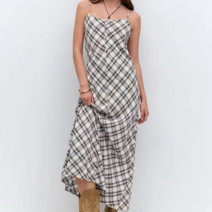 Rutig långklänning med smala axelband - Supersnygg långklänning med smala axelband och rutigt mönster i svart, grått och vitt. Klänningen har en rak, flowy passform och är perfekt för dig som gillar en stilren men ändå trendig look. Materialet känns svalt och lätt mot huden. Helt ny, använd vid 1 tillfälle!