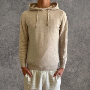 Beige hoodie i merinoull från Garde Grisch - Säljer en beige hoodie från Garde Grisch i storlek XS jag har satt den som s för den sitter ganska så på mig som är 177 men den passar nog om du brukar har s och xs men jag är smal. tillverkad i 100% mjuk merinoull. Tröjan har huva med snörning, ribbade muddar och lång ärm. Perfekt för dig som gillar stilrena och sköna plagg med clean look.