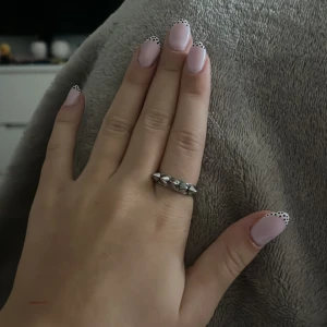 Silvrig ring med nitar - Cool silvrig ring med flera små nitar runt hela bandet. Perfekt för dig som gillar edgy och unik stil. Ringen är i metall och har en chunky känsla som sticker ut på handen.