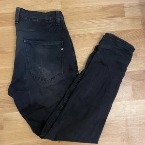 Replay svarta slim jeans med slitningar - Svarta jeans från Replay med slim passform och snygga slitningar på både fram- och baksida. 32/32.